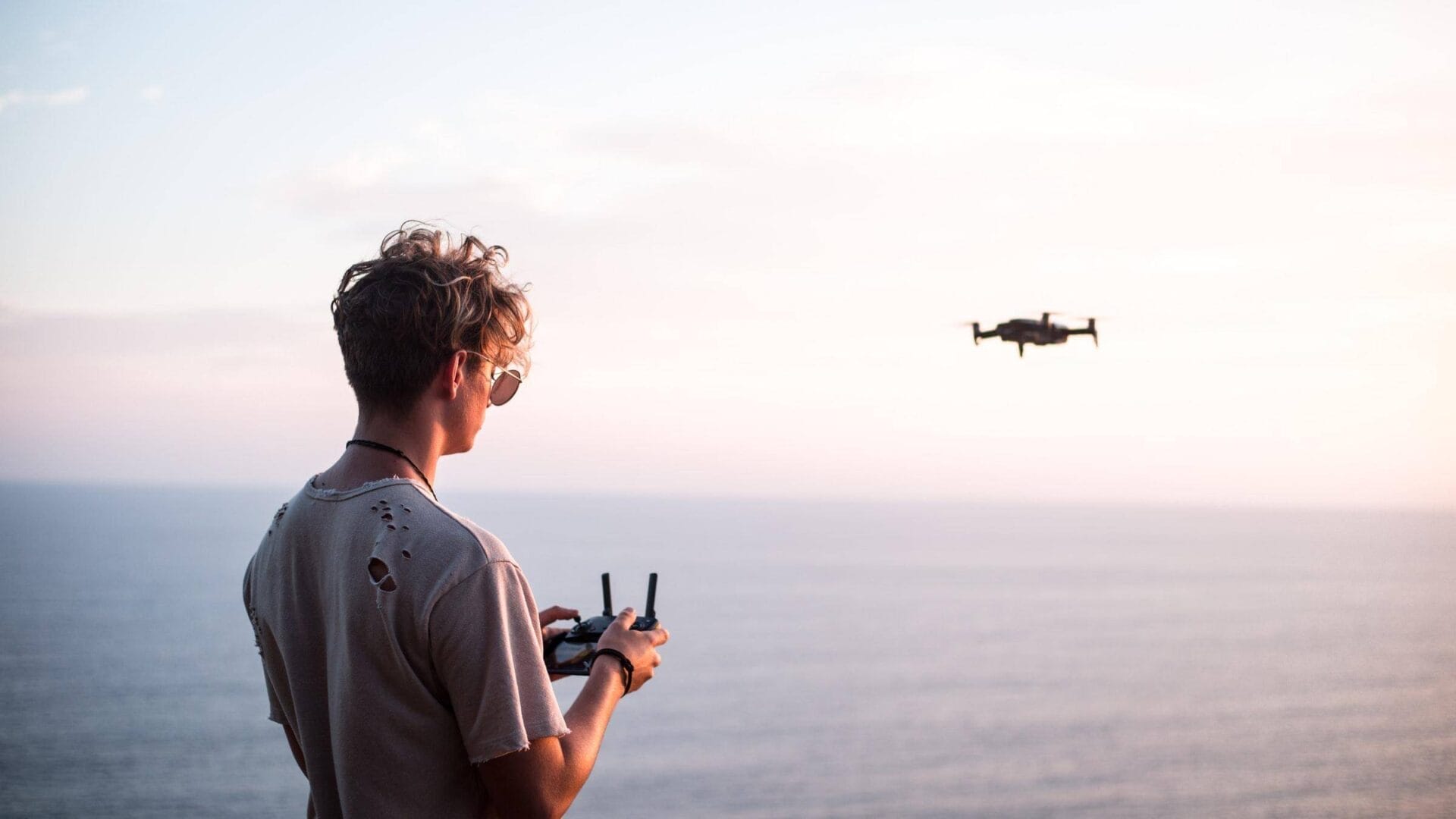         Description: A man is flying a drone over the ocean, capturing stunning aerial footage through AWS.