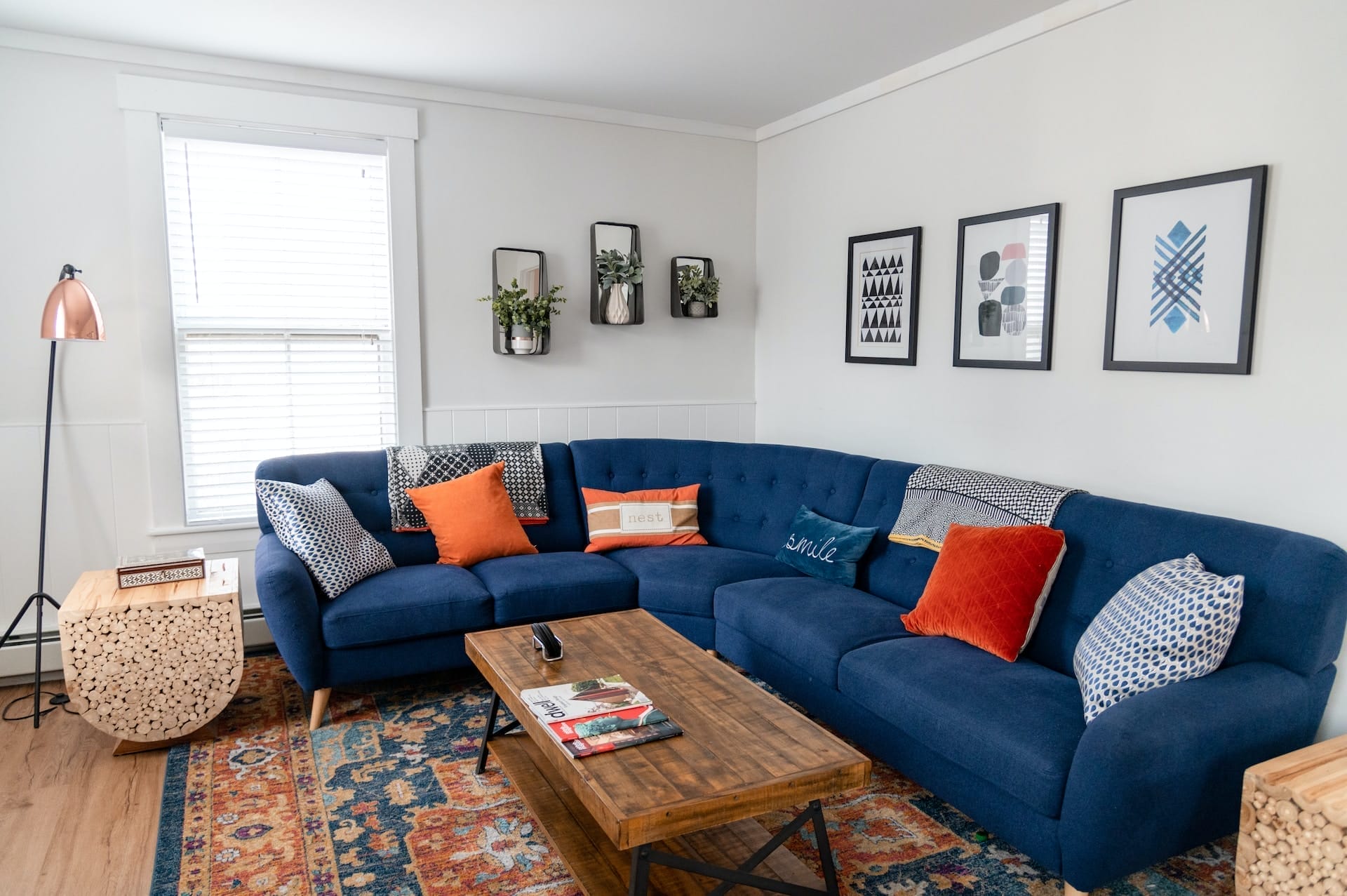 A living room with a blue couch and orange rug perfect for showcasing home decor on a marketing website powered by Webflow.